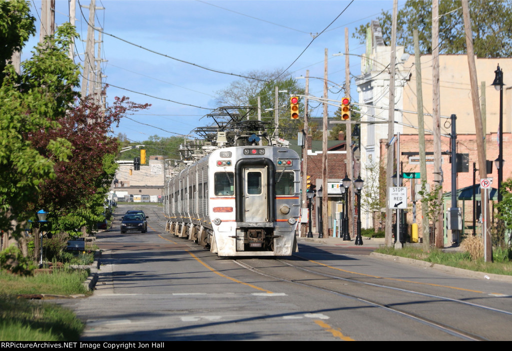 Traffic waits in the road as the train heads west